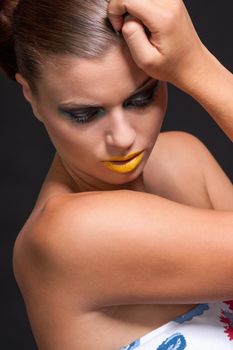 woman with extreme colorfull make up in blue and yellow on black background