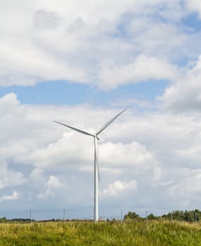 three-bladed wind generator with a horizontal axis of rotation on sky background