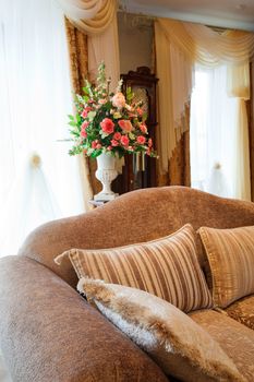 bouquet of beautiful flowers in the vase near the window