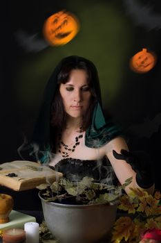 Witch making magic with book on Halloween night
