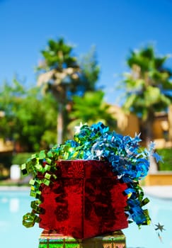 Red Gift box with ribbon by the swimming pool