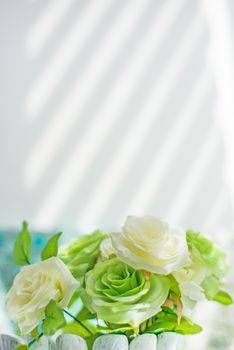 bouquet of green and white roses on the windowsill