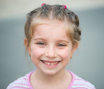 cute little girl smiling in a park close-up