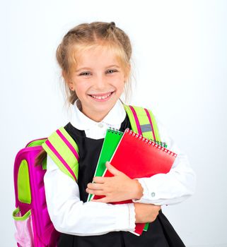 little cute smiling girl with stationery on a white background