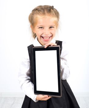 cute smiling schoolgirl with a pc tablet on light background