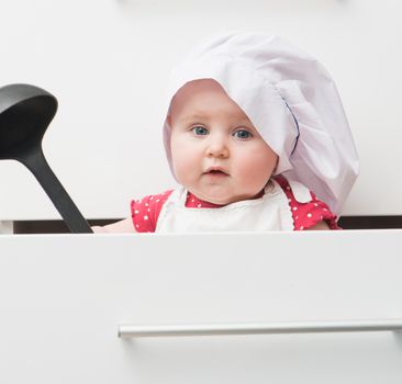 little fun baby with a chef's hat in the kitchen