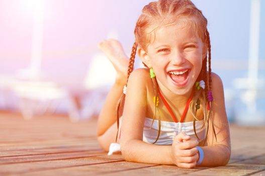 smiling girl lies on a timber floor