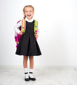 little cute girl with backpack on a white background