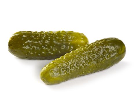 Photo of two isolated pickles on white background.