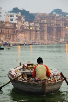 Varanasi, circa Dec.2010. A unidentified lone boatman selling trinckets from his boat to the passing by boats with tourists on the Ganges near Varanasi