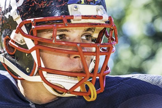 Portrait of a American Football Player with a heavily worn helmet