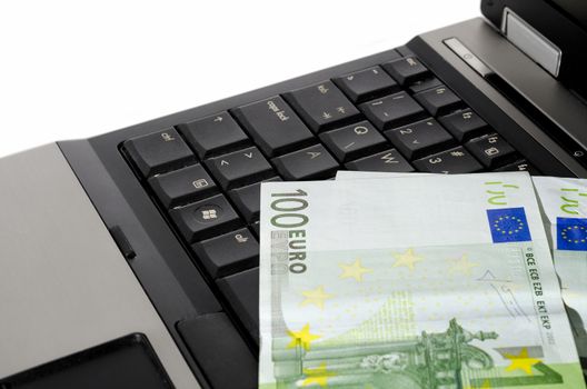 close up of a laptop computer with couple of euro notes on the keyboard horizontally cropped