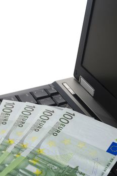 close up of a laptop computer with couple of euro notes on the keyboard vertically cropped