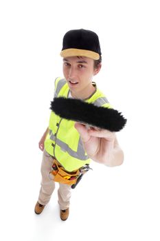 Young handyman teenage apprentice painter wearing work clothes and holding a paintbrush.  White background