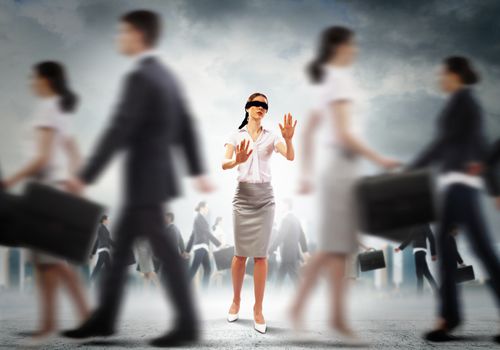Image of businesswoman in blindfold walking among group of people