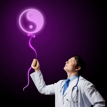 Image of young male doctor and sign of yin yang