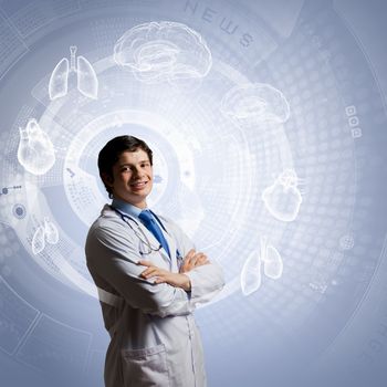 Young concentrated male doctor with arms crossed against digital background
