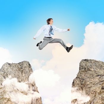 Image of young businessman jumping over gap