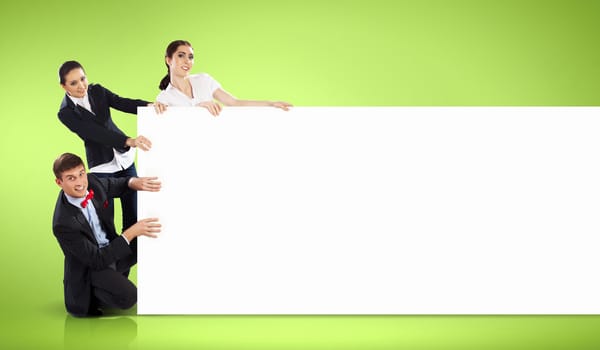 Image of three young people holding blank banner against green background. Place for text