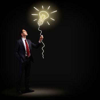 Image of businessman in black suit against dark background