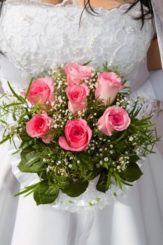 pink roses are in the hands of fiancee