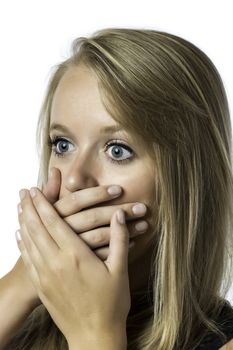 Portrait of shocked young girl who is afraid and keeps up with eyes wide open hand over her mouth, isolated on white background