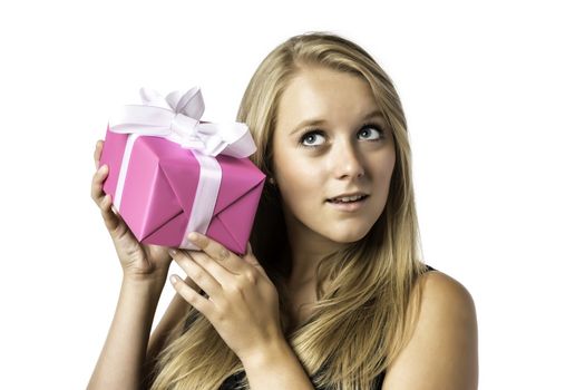 Young blond girl listens to a gift, isolated on white background