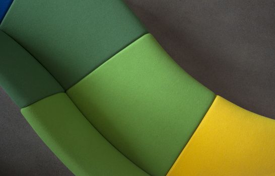 Detail of a curved sofa in green and yellow,  shot from above