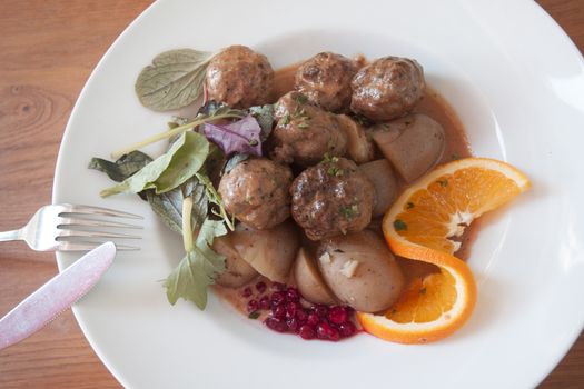 Traditional swedish meatballs served in a five star restaurant wtih orange as decorations
