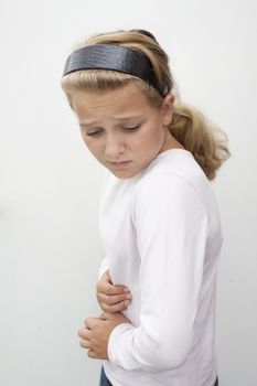 A young girl folding forward from pain in tummy