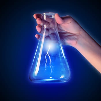 Close up image of human hand holding test tube with lightning