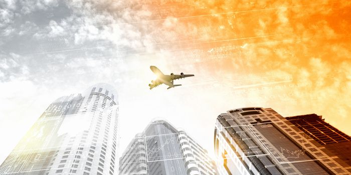 Plane flying above skyscrapers. Business travel concept