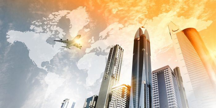 Plane flying above skyscrapers. Business travel concept