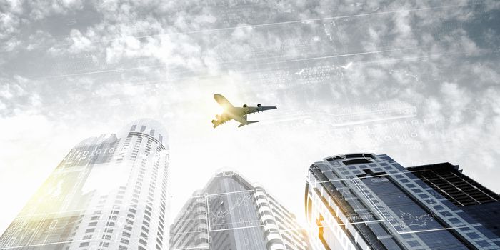 Plane flying above skyscrapers. Business travel concept