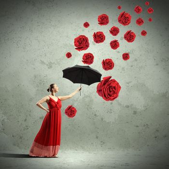 ballet dancer in flying satin dress with umbrella and flowers