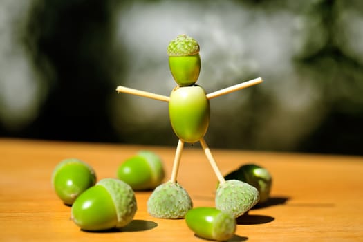 Little man made of green acorns 