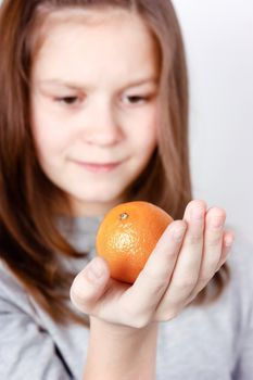 teen girl holding in the palm of mandarin