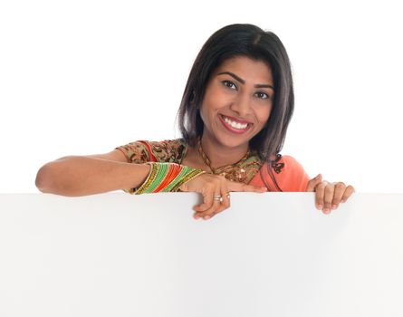 Traditional Indian woman in sari holding blank billboard. Portrait of attractive young Asian female model isolated on white background.