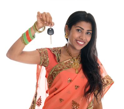 Attractive traditional Indian woman in sari holding her first own car key isolated on white background. Beautiful Asian woman model.