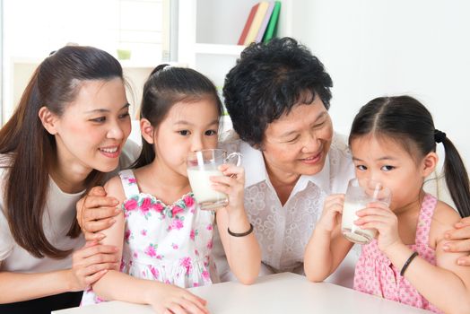 Drinking milk. Happy multi generations Asian family at home. Beautiful grandmother, mother  and granddaughters, healthcare concept.