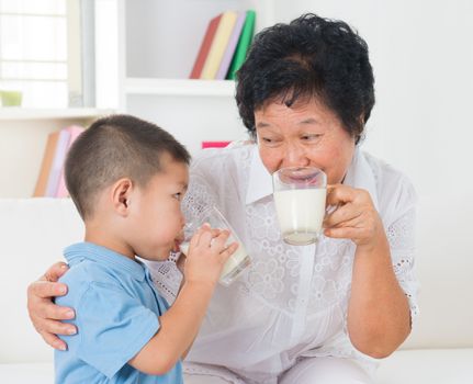 Drinking milk. Happy multi generations Asian family drinking milk at home. Beautiful grandmother and grandson, healthcare concept.