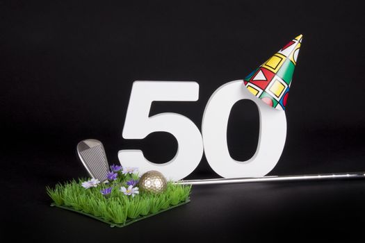 A golf club and golf ball on an artificial peace of grass to be used as a birthday card