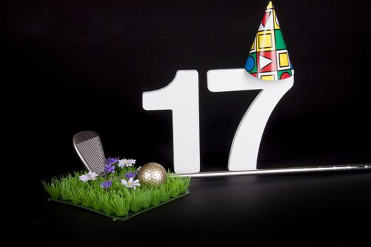 A golf club and golf ball on an artificial peace of grass to be used as a birthday card