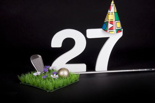 A golf club and golf ball on an artificial peace of grass to be used as a birthday card