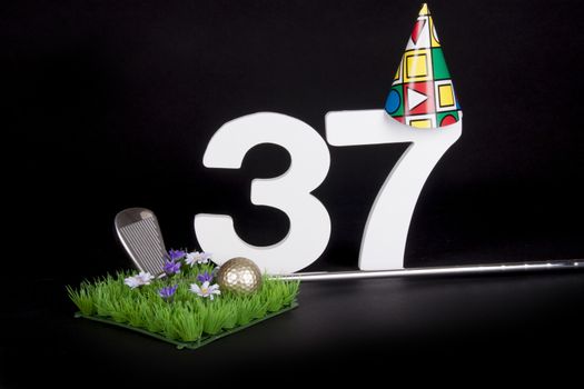 A golf club and golf ball on an artificial peace of grass to be used as a birthday card