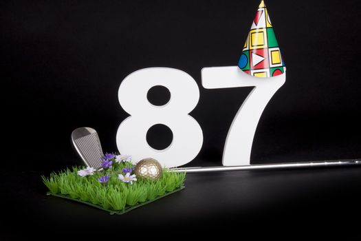 A golf club and golf ball on an artificial peace of grass to be used as a birthday card