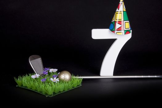 A golf club and golf ball on an artificial peace of grass to be used as a birthday card