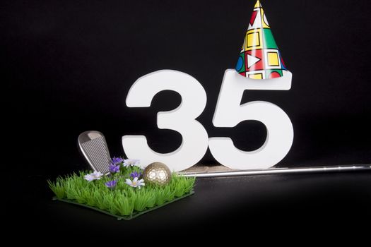 A golf club and golf ball on an artificial peace of grass to be used as a birthday card