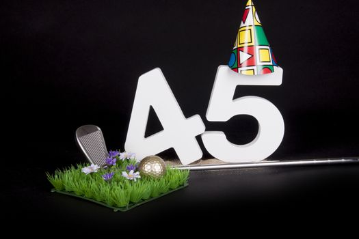 A golf club and golf ball on an artificial peace of grass to be used as a birthday card