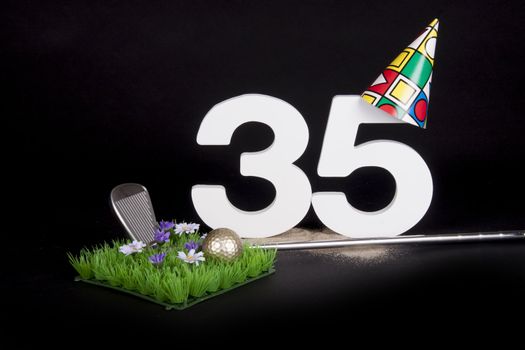 A golf club and golf ball on an artificial peace of grass to be used as a birthday card